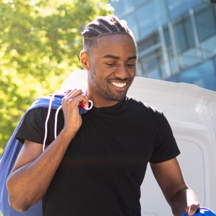 Malcolm, fondateur de Sekura, un sac de linge sur l'épaule lors d'une rotation.